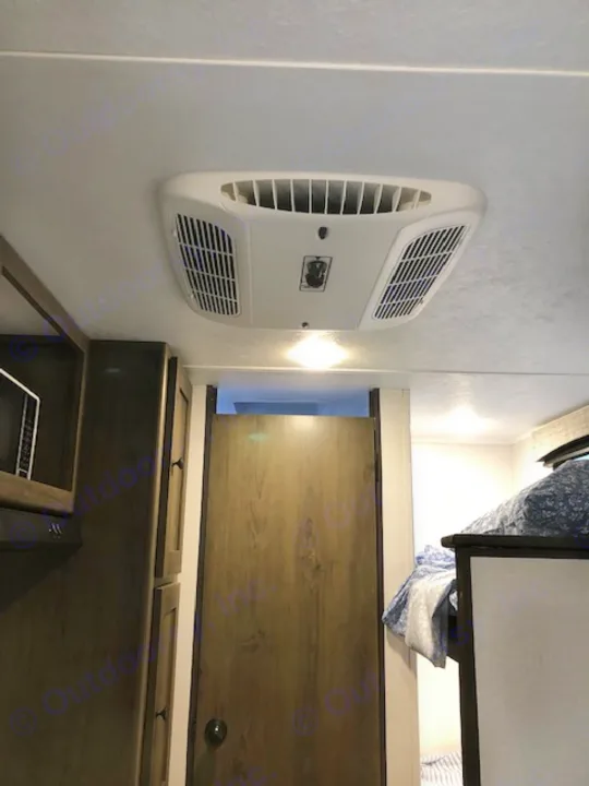 This RV rental interior shows an AC unit, upper bunk bed with bedding, and a lower wooden cabinet/kitchen area.. Forest River Coachmen RV Clipper Ultra-Lite 17BH 2022