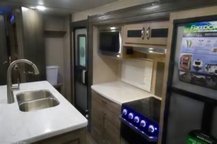 Modern RV rental interior: well-equipped kitchen with sink, microwave, stove, & fridge for comfortable travel.. Coachmen Other 2020