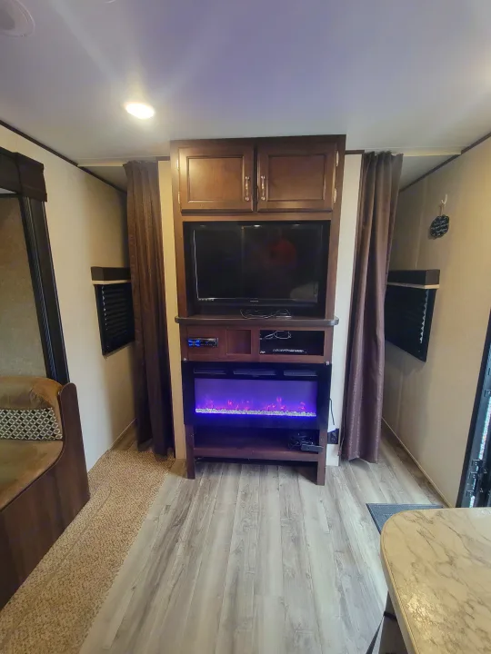 RV rental: Modern living area featuring an entertainment center with a TV, electric fireplace, and comfy seating.. Jayco Jay Flight SLX 2018