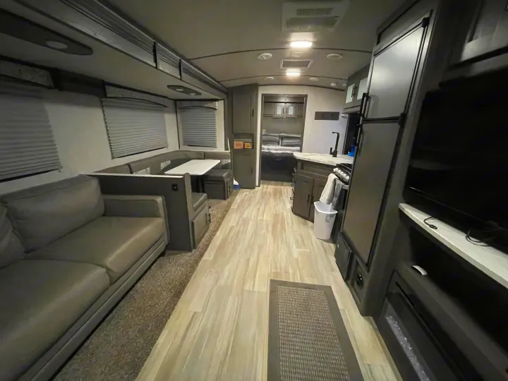 View of a well-appointed RV rental interior featuring a living area, dinette, kitchen, & bedroom.. Cruiser RV MPG Ultra Lite 2021