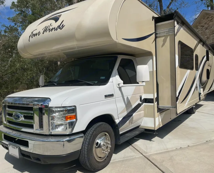 This Four Winds Class C rv rental, a Ford E-450 motorhome, is beige and white with an extended slide-out.. Thor Four Winds 2017