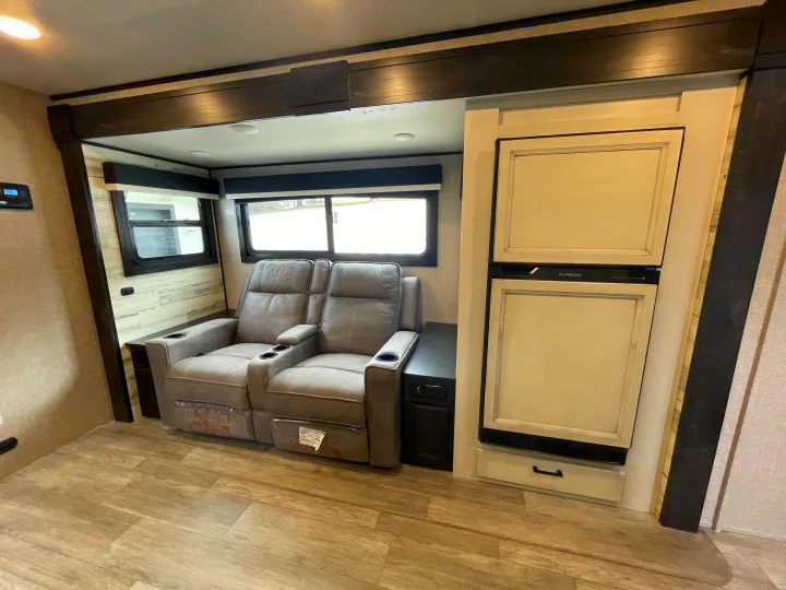 Comfortable RV rental interior featuring recliners, large windows, and a refrigerator, perfect for travel.. Jayco Jay Feather 2022