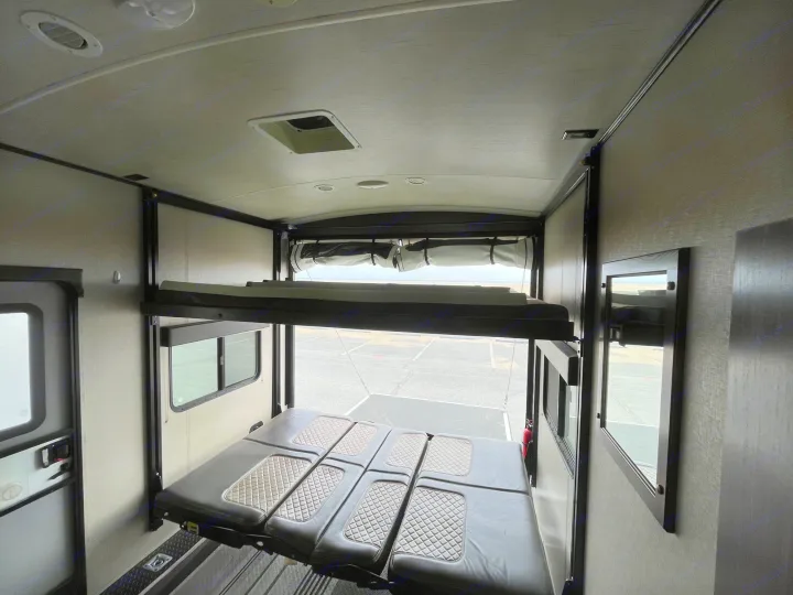 RV rental toy hauler interior: spacious garage area with a lower convertible bed and an upper bunk. Rear ramp open.. Other Other 2017