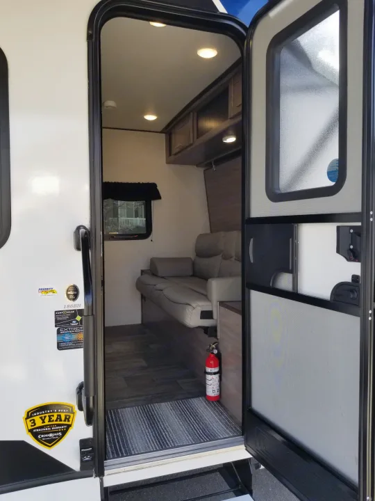 View inside an 186BH RV rental: an inviting space with sofa, overhead storage, and a screen door. Built for diverse weather.. Crossroads RV Sunset Trail Super Lite 2021