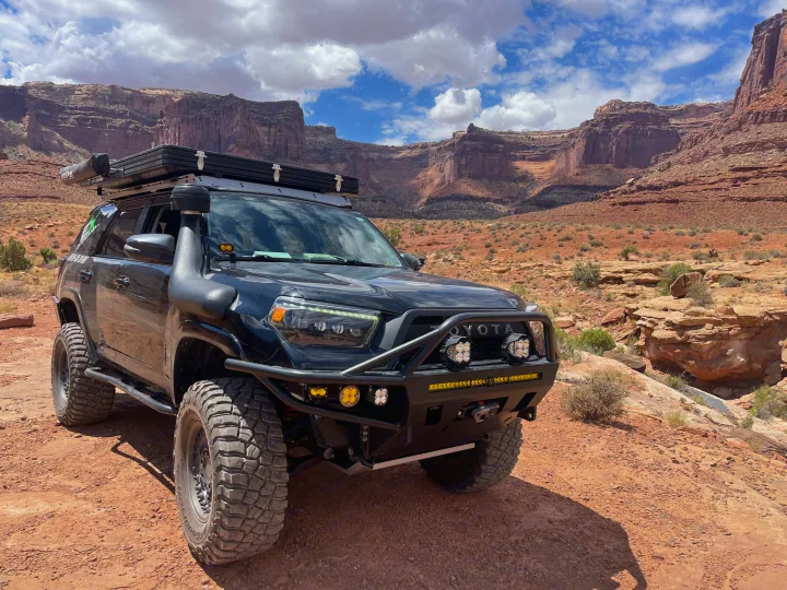 Modified Toyota 4Runner with rooftop tent & snorkel in a desert landscape, ideal for an **rv rental** adventure.. Toyota 4Runner 2013