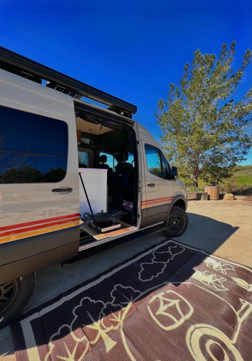 This RV rental, a Storyteller Overland van, is set up for van life with an outdoor kitchen and mat.. Storyteller Overland Beast Mode 2023