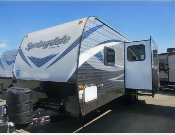Springdale travel trailer for your RV rental. Gray and black with blue accents, ideal for camping adventures.. Keystone RV Springdale 2019