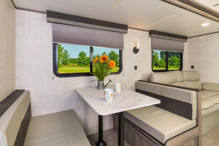 Cozy RV rental interior featuring a dinette, sofa, and scenic outdoor views, ideal for comfortable travel.. Gulf Stream 268BHS 2023