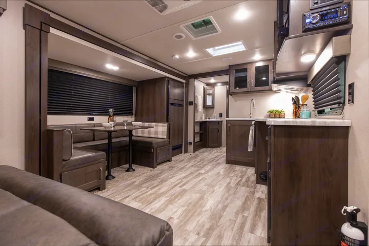 RV rental interior: modern kitchen, comfortable dinette, and inviting living area with light wood-look flooring.. Grand Design Transcend Xplor 265BH 2022