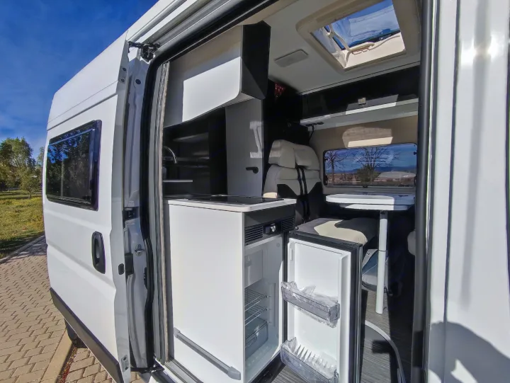 Inside a white RV rental: compact kitchen, open fridge, dining space, and skylight. Ready for travel!. McLouis MENFYS 3 MAXI 2026
