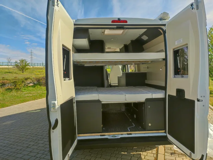 Open rear of an RV rental: versatile interior with bunk beds, a lower sleeping area, and built-in storage.. McLouis MENFYS 3 MAXI 2026