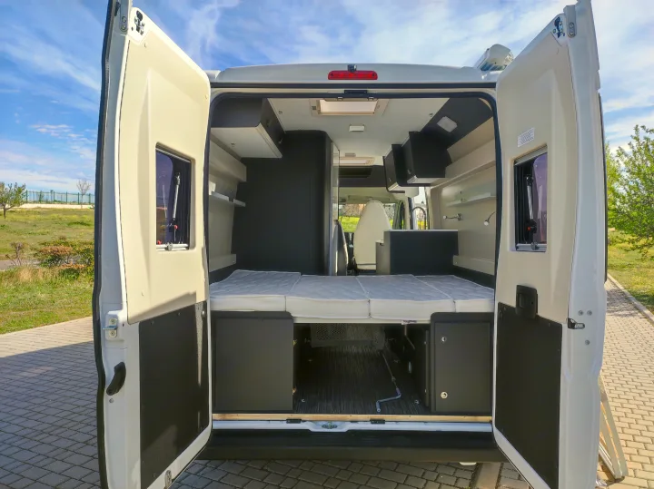 Experience comfort on wheels with this RV rental! View of a modern camper van's spacious interior, featuring a cozy bed and ample storage.. McLouis MENFYS 3 MAXI 2026