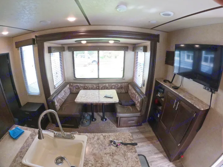 Explore this cozy RV rental interior: kitchen with sink, dining booth, and TV entertainment space.. Forest River XLR Boost Toy Hauler 2018