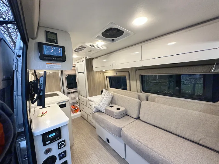 Modern rv rental interior showing a compact kitchen, comfortable living space, and digital control panels for a cozy travel experience.. Thor Tellaro 2022