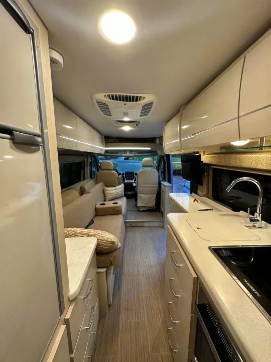 RV rental: Bright, modern interior with kitchen, sofa, and front cabin view, perfect for road trips.. Thor Tellaro 2022