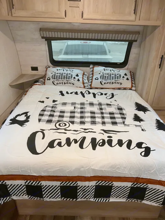 Cozy RV rental bedroom with camping-themed bedding, ideal for a comfortable stay.. Escape e231bh 2022