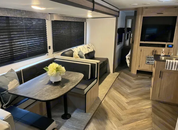 Spacious RV rental interior with a modern dinette, full kitchen, and stylish herringbone floors. Ideal for your next trip.. Heartland RVs Prowler 2022
