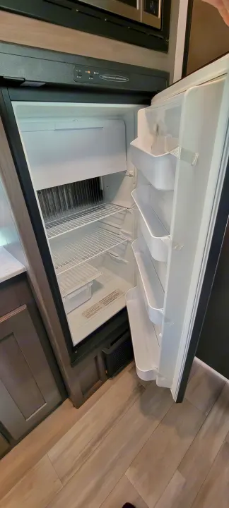 Inside an rv rental, a clean, empty refrigerator with shelves & controls. Ready for your adventure!. Heartland RVs Mallard 2022