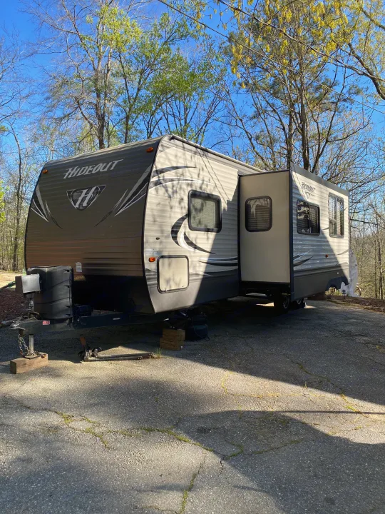 A Hideout travel trailer is parked and set up on a sunny day, ready for your RV rental adventure.. Keystone RV Hideout 2016