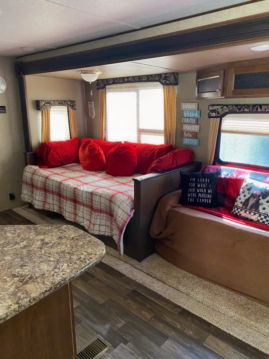 An inviting RV rental interior features a daybed, comfy sofa, and personalized decor, creating a cozy living space.. Keystone RV Hideout 2016