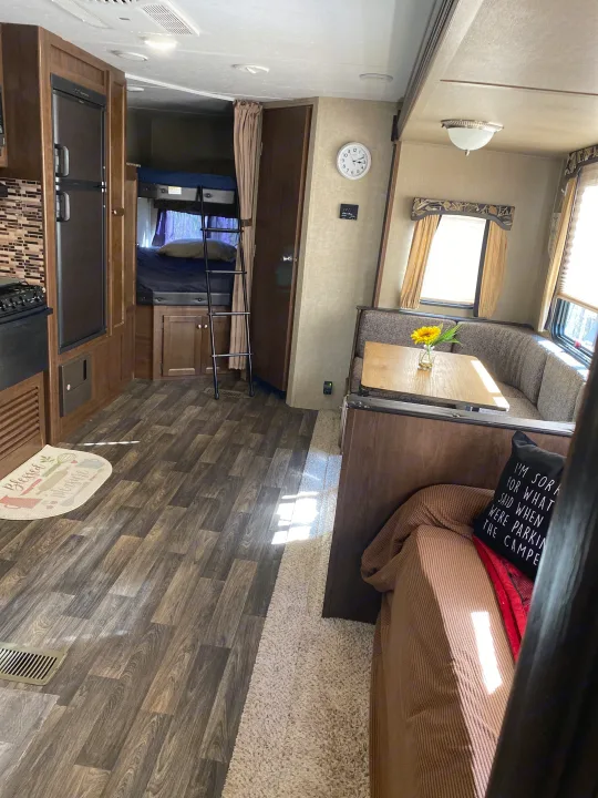 Spacious RV rental interior features bunk beds, a kitchen, and a cozy dining area, perfect for travel.. Keystone RV Hideout 2016