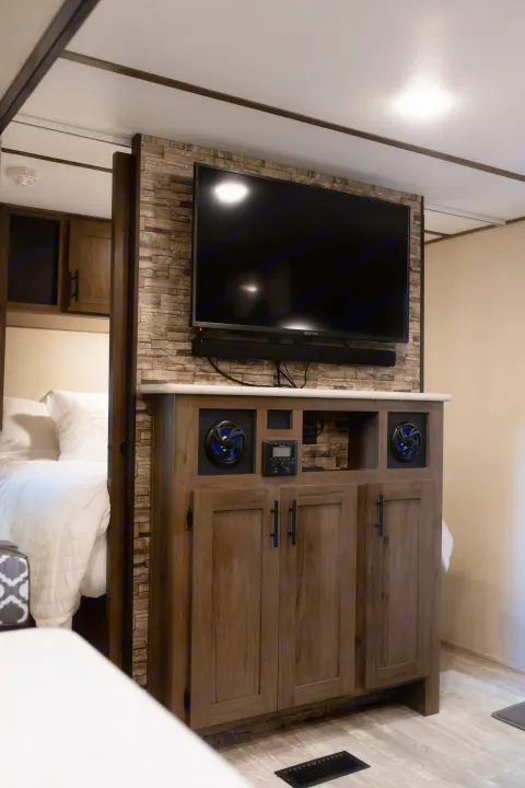Modern RV rental interior with TV, entertainment system, and a glimpse of the bedroom area.. Avenger ATI 2020