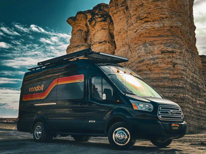 Customized black Ford Transit Vandoit rv rental parked among towering rock formations, ready for adventure.. Vandoit DO 2019