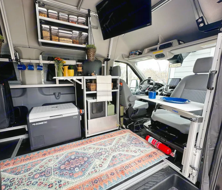 This cozy rv rental interior features clever storage, a fridge, kitchen setup, and a versatile Lagun table for comfortable travel.. Vandoit DO 2019
