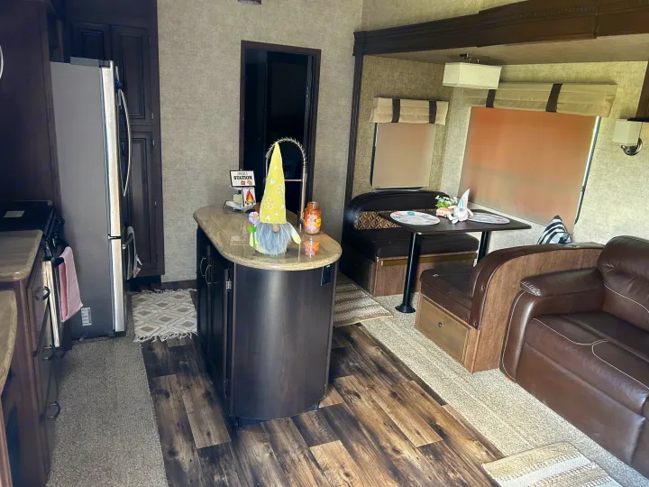 Cozy RV rental interior with kitchen island, dinette, and living area. Perfect for travel adventures.. Forest River Sandpiper 2018