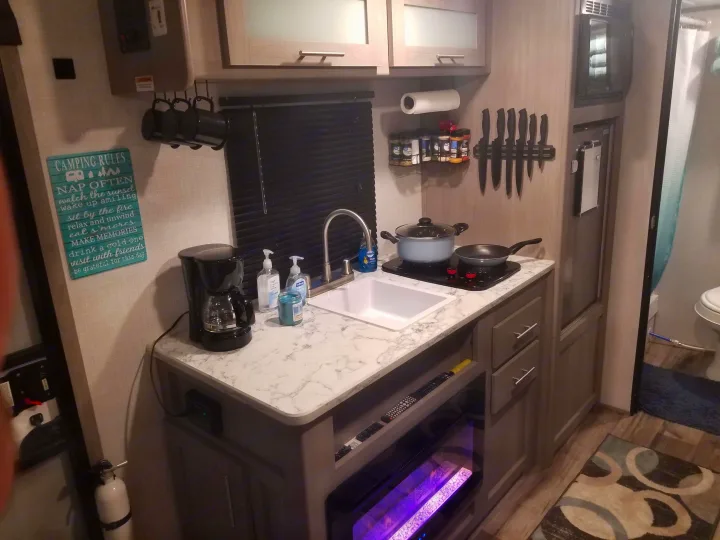 Small, functional RV rental kitchen with essential cooking amenities for your adventures.. Coleman Lantern 17B 2023