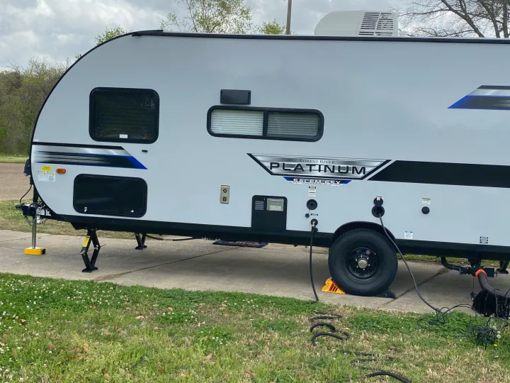 Side view of an rv rental: a light grey Forest River travel trailer, fully set up on a pad.. Forest River Salem FSX PLATINUM 2021