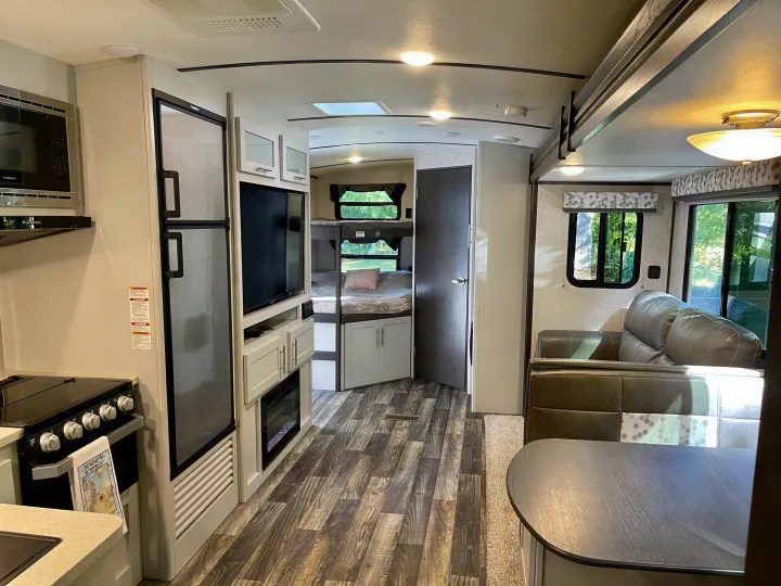 Spacious RV rental interior with kitchen, dining, and bunk beds. Modern amenities for comfortable travel.. Keystone RV Bullet Premier Ultra 2020