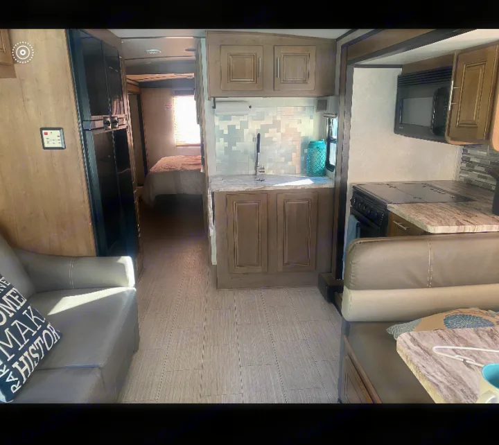 Spacious RV rental interior showing a kitchen, living area sofa, and a bedroom in the back.. FR3 FR3 Motorhome 2020
