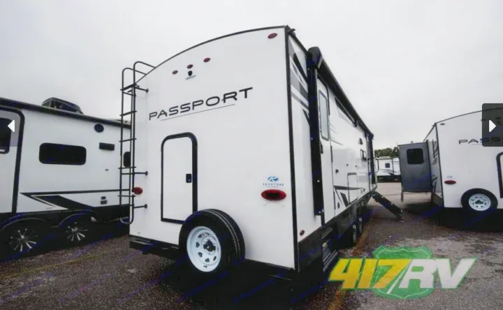 White Keystone Passport travel trailer. Ideal for your next rv rental adventure. Visible ladder & spare tire.. Keystone RV Passport GT 2022