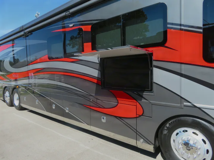 Luxury motorhome RV rental, gray with red accents, featuring a pull-out outdoor TV for entertainment.. Monaco Signature 2019