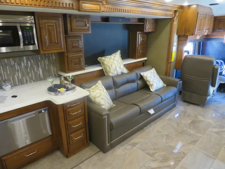 Spacious RV rental interior with kitchen, living area featuring comfy sofa, entertainment setup, and modern appliances.. Monaco Signature 2019