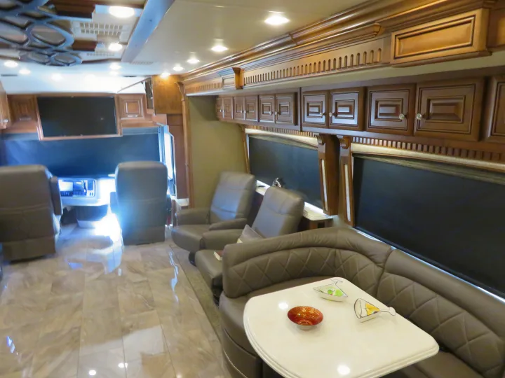 An inviting RV rental living room with plush seating, elegant wood trim, and polished tile flooring for your journey.. Monaco Signature 2019