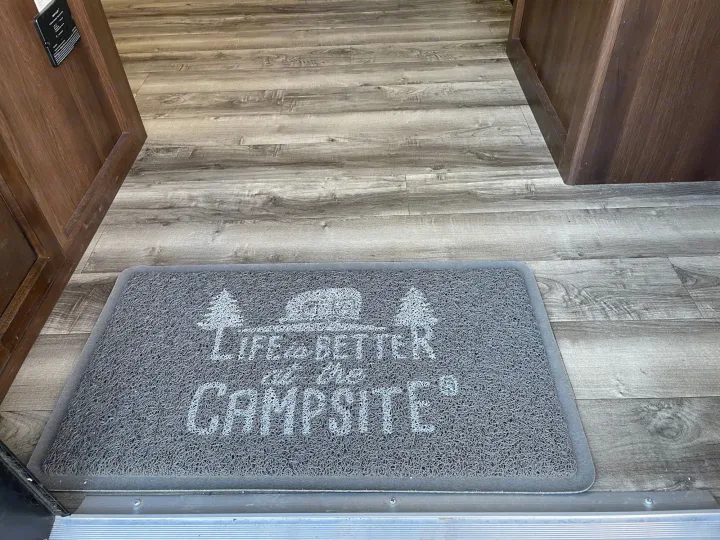 RV rental interior: A 'Life's Better at the Campsite' doormat welcomes you onto wood-look flooring near the entrance.. Jayco Jay Flight 2018