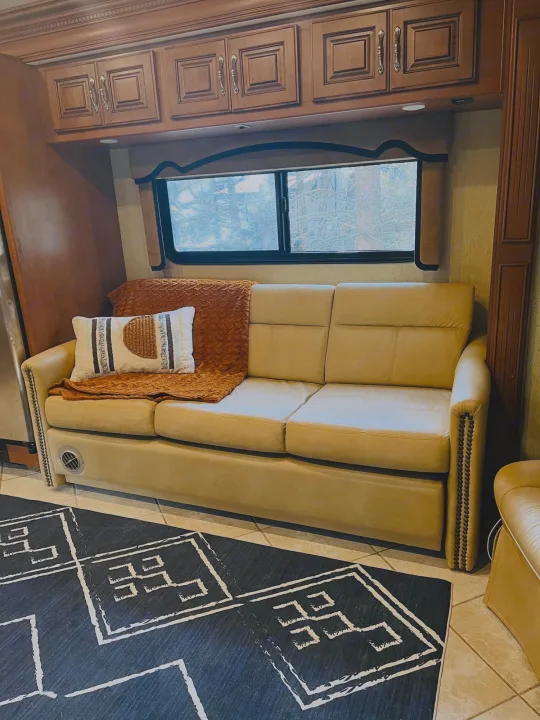 Relax in this spacious RV rental with a comfy leather sofa, ample storage cabinets, and a large window for scenic views.. Fleetwood Discovery 2011
