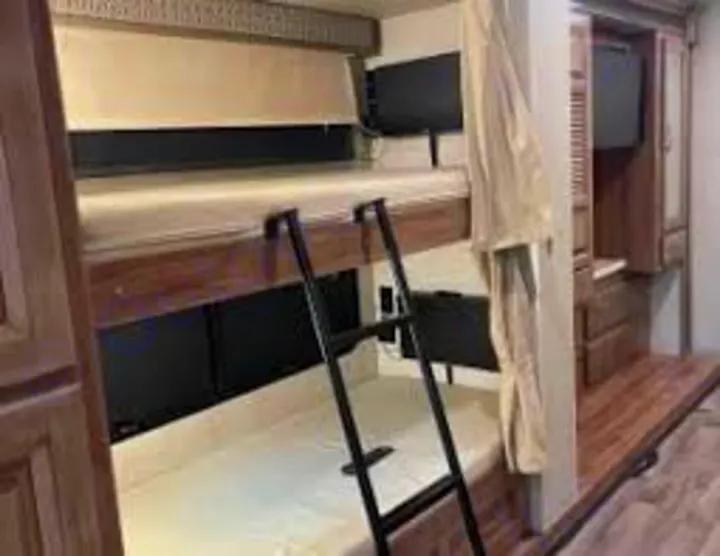 Cozy RV rental bunk beds: comfortable interior sleeping area for travel, complete with ladder and TV for your next adventure.. Jayco Precept Prestige 2021
