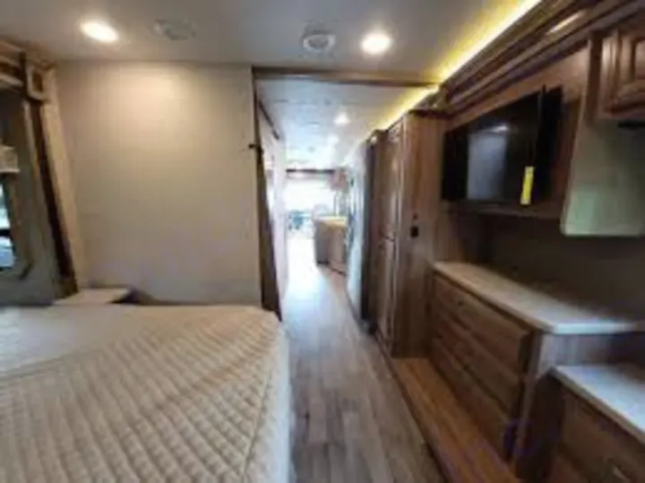 Inside this modern RV rental, see the bedroom, hallway, and living area with TV and wood cabinetry. Ready for your adventure!. Jayco Precept Prestige 2021