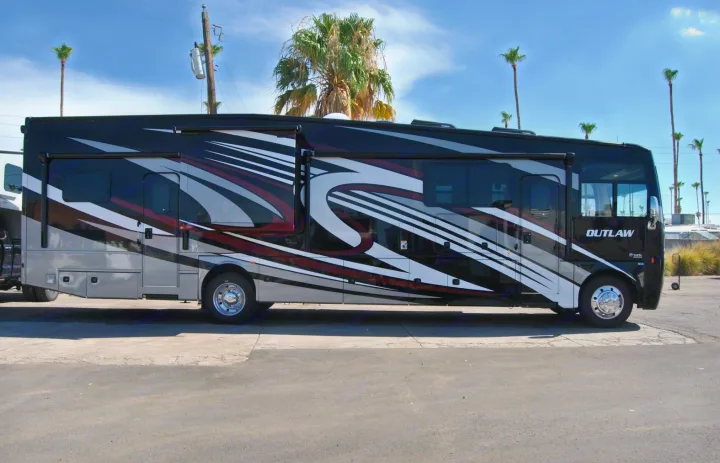 Sleek black and silver RV motorhome with a bold graphic design, perfect for an rv rental adventure.. Thor Motor Coach Outlaw 2023