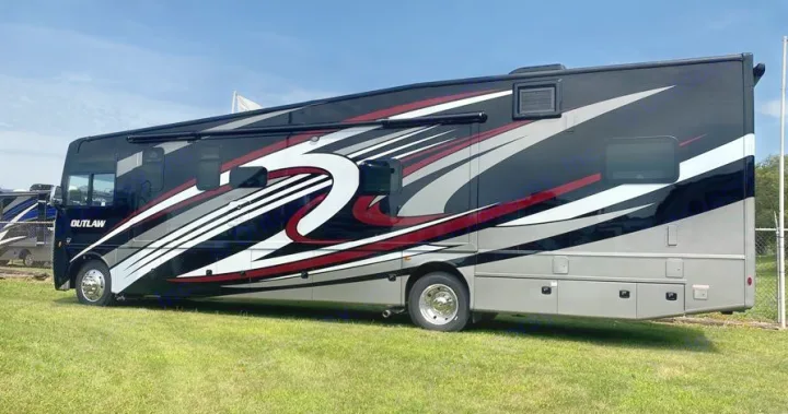 Experience an rv rental in this eye-catching Outlaw RV. A large black, gray, and red motorhome with bold graphic details.. Thor Motor Coach Outlaw 2023
