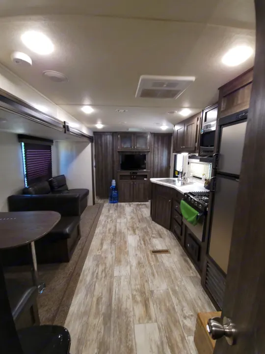 Spacious RV rental interior: modern kitchen, cozy living area, wood-look floors.. Highland Ridge RV Open Range Conventional OT26BHS 2019