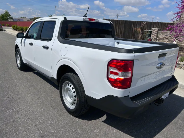 White Ford Maverick pickup truck, seen from the rear-right on a sunny day. A practical choice for daily use or an RV rental adventure.. Ford Maverick 2024
