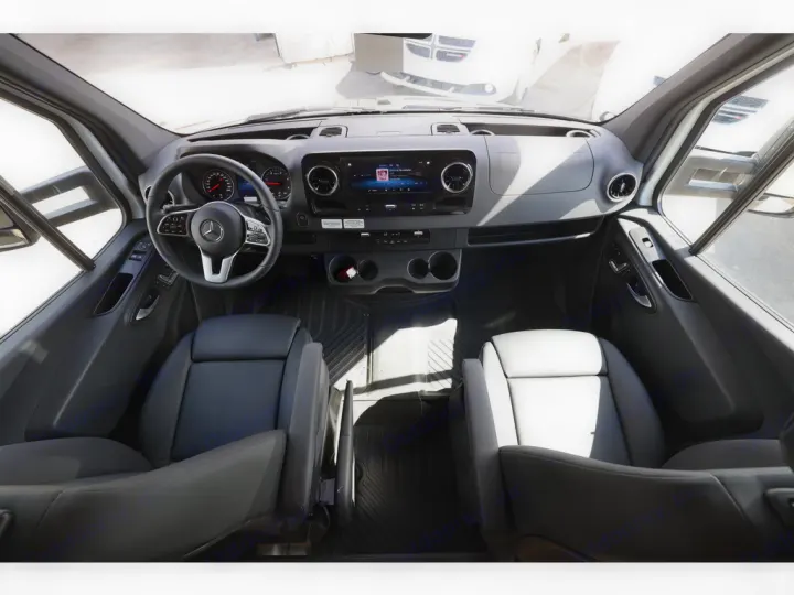 Inside an **RV rental**: driver's cockpit featuring steering wheel, dashboard with screen, and comfortable front seats.. Entegra Coach Qwest 2020