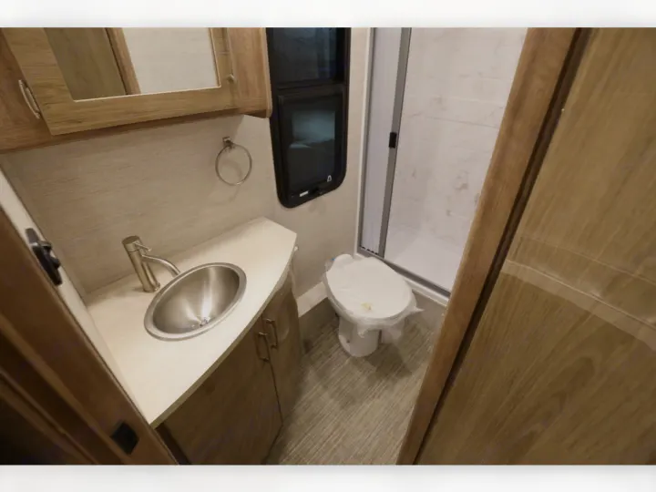 RV rental bathroom: modern sink, toilet, & standing shower. Compact and efficient for comfortable travel.. Entegra Coach Qwest 2020