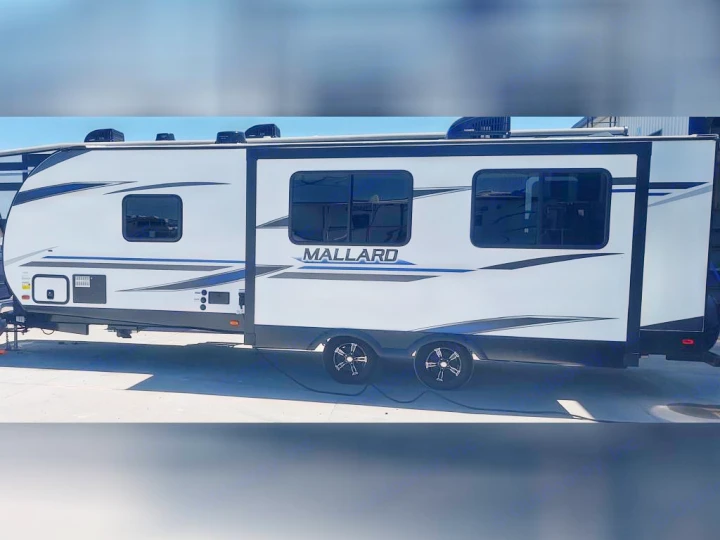 A sleek white Mallard travel trailer, an ideal RV rental for your next road trip.. Heartland RVs Mallard 2022