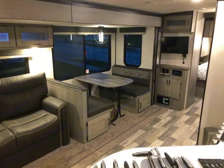Inside an RV rental: a modern living space featuring a sofa, dinette, wall-mounted TV, and ample storage for comfort.. Heartland RVs Mallard 2022