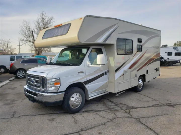 This beige and white Ford E-350 Class C RV rental is parked on an asphalt lot, ready for your next adventure.. Forest River Coachmen Leprechaun 2017